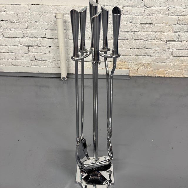 Chrome Art Deco Style 4-piece fireplace tool set from the 70s which icludes a poker, a shovel, a brush, tongs all held...