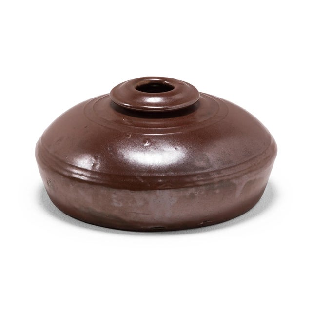 This unusual squat vessel would have been kept near a kang platform to warm one's blankets before bed. Much like a hot...