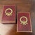 Listing is for a pair of deep red leather book ends with gilt embossed borders and large brass Laurel wreath in center....