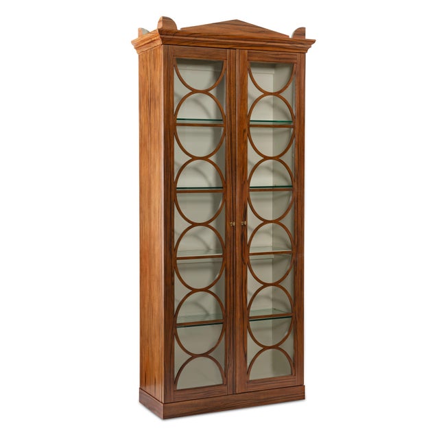 A refined display cabinet that combines architectural structure with timeless design. The tall form features circular...