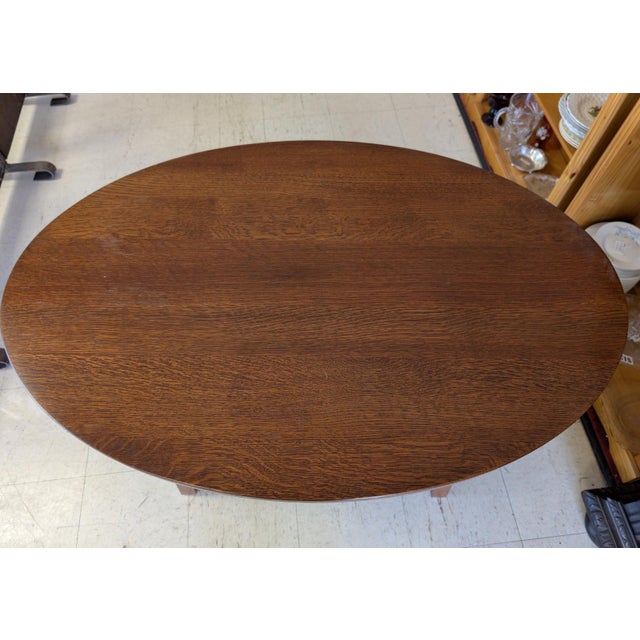 A beautifully executed Arts & Crafts / Mission-style oval library table by Stickley, bearing both the branded mark and...