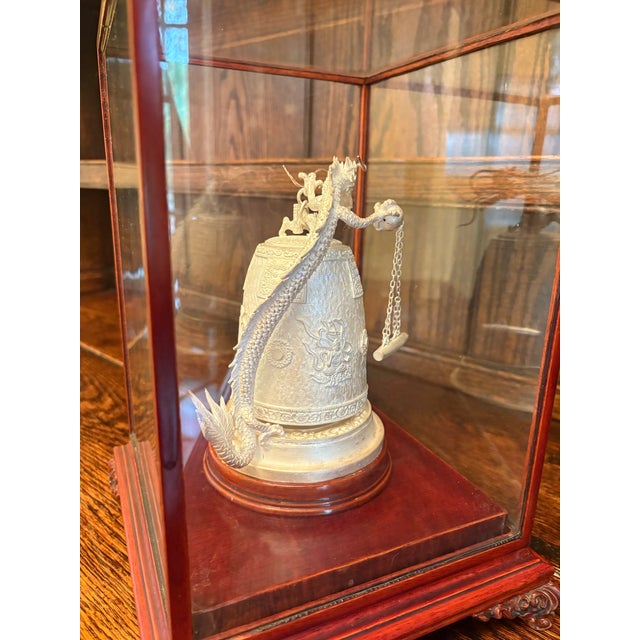 This decorative Chinese-style bell features an elaborately modeled dragon wrapped around a traditional bell form, rendered...