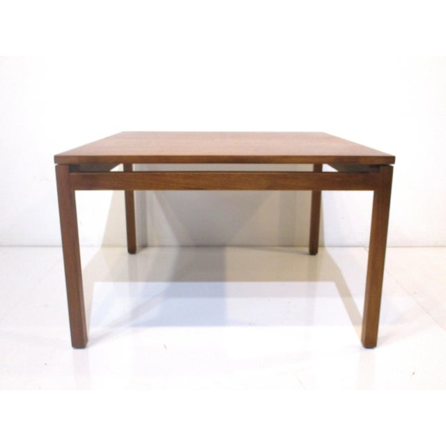 A nice sized square medium dark walnut coffee table with floating styled top design in a very well crafted manner . An...