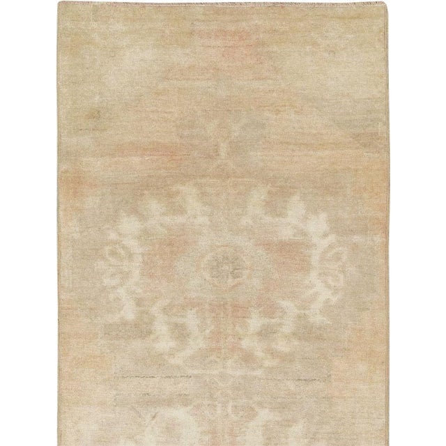 This mid-20th-century Turkish Anatolian runner presents a softly understated composition in pale sand, warm ivory, muted...