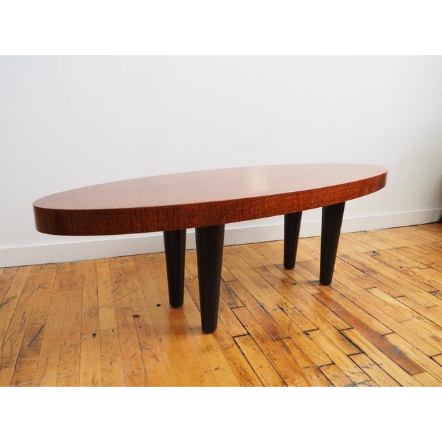 An oval postmodern coffee table in the manner of the Pace Collection in impeccable condition with ebonized legs and a...