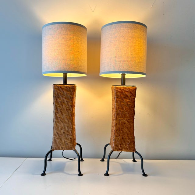 Vintage pair of Paul Mayen style rattan and iron footed table lamps with linen barrel shades.