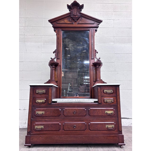 This is a large antique Victorian Eastlake walnut dressing stand, dresser, or bedroom vanity, circa 1870–1885. Features...