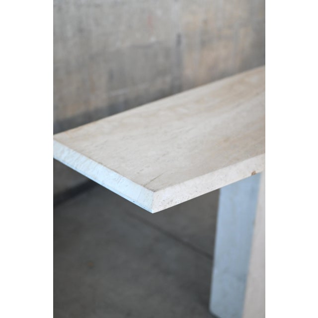 A bold and angular postmodern period travertine table. Tan with subtle variegation, fine beveled edges and a pedestal...