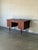 This double pedestal desk features eight side drawers and a wide central drawer. Tapered legs and recessed carved handles...