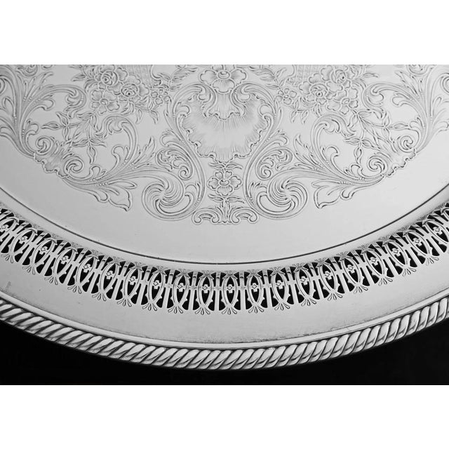 This lovely vintage silverplate tray features an ornate etched surface, pierced gallery sides, and a classic corded...