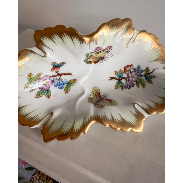 A beautifully hand-painted porcelain dish by Herend, decorated in the beloved Queen Victoria pattern. This elegant form...