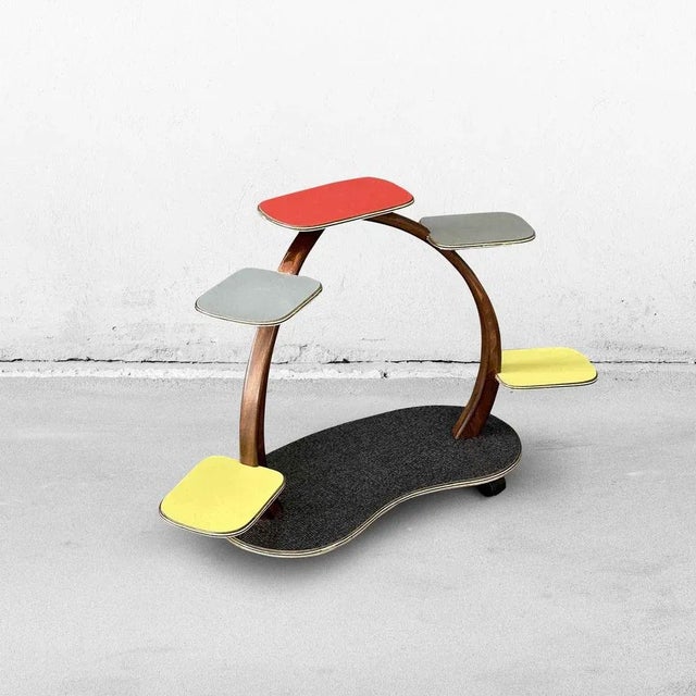 Mid-century plant stand from the 1960s. This colorful little table is made of wood and Formica in yellow, gray, red, and...