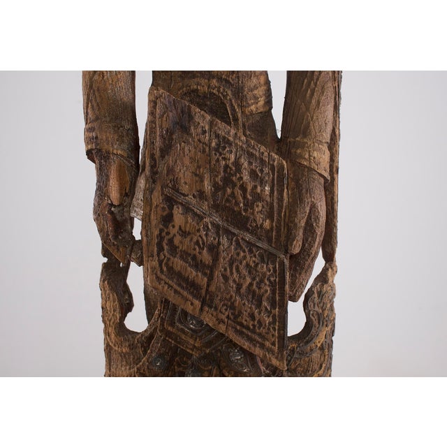 An imposing Burmese wooden statue representing a sky deity. Burma, 18th century. The sculpture is presented on a steel...