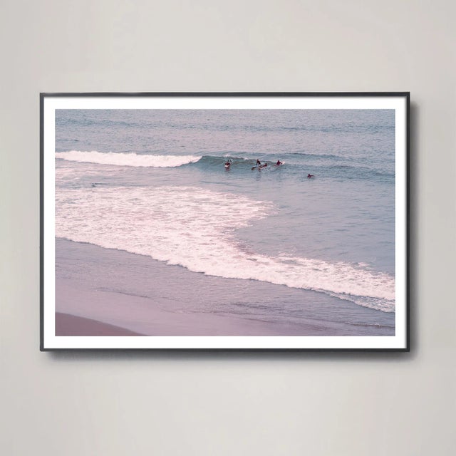 This dramatic composition of surfers along the Santa Barbara coast has vintage tones that reference classic surf...