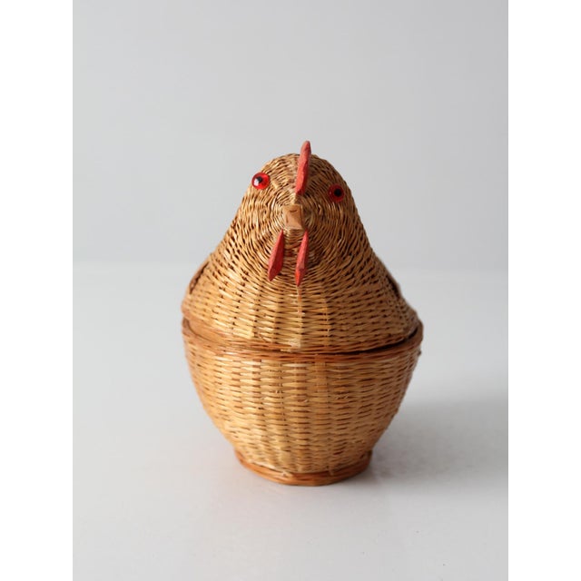 A handwoven wicker chicken basket in a warm natural tone, shaped with subtle variation that highlights its artisanal...