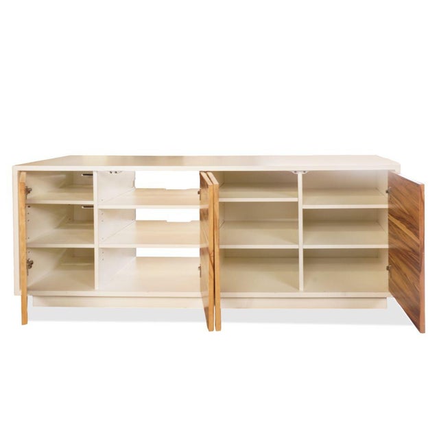 A warm interplay of material and form defines the Wüd Red and White Media Console, where organic wood grain meets a clean...