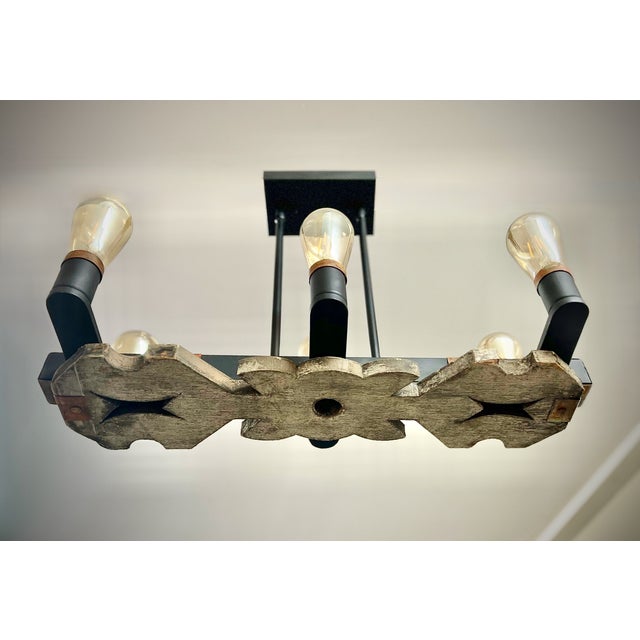 This striking, one-of-a-kind chandelier merges reclaimed craftsmanship with vintage industrial style — centered around a...