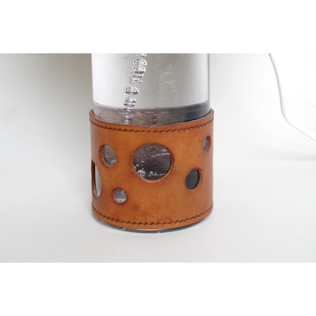 - Glass lamp with a cylindrical barrel containing air bubbles - Bottom is covered with a fawn openwork leather ring -...