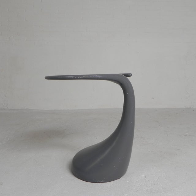 The elegant small table stands on a wide leg that tapers towards the top and transitions organically into a round top with...