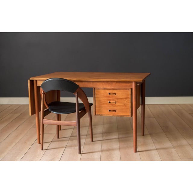 Mid Century Modern drop leaf desk in teak designed by Arne Vodder, circa 1960s. This versatile piece features a sliding...
