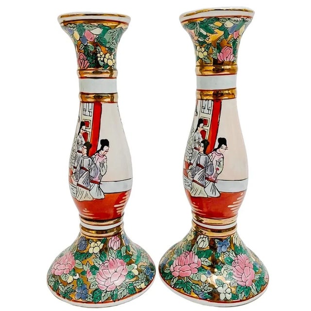A classic pair of Chinese export candlestick holders featuring a hand-decorated Rose Medallion allover design with figural...