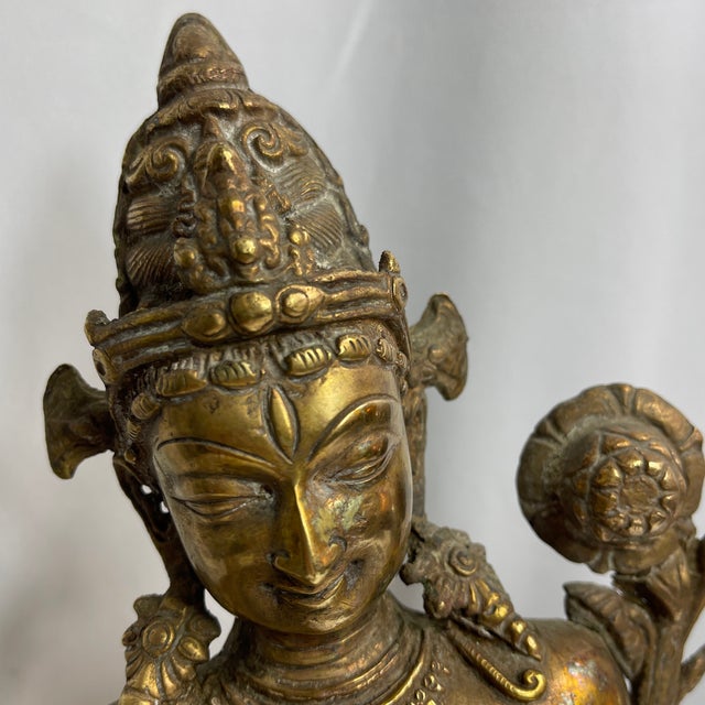 Sculptural depiction of a female Boddhisatva, possibly tara, made of hollow cast brass, tara placed on a base in the form...