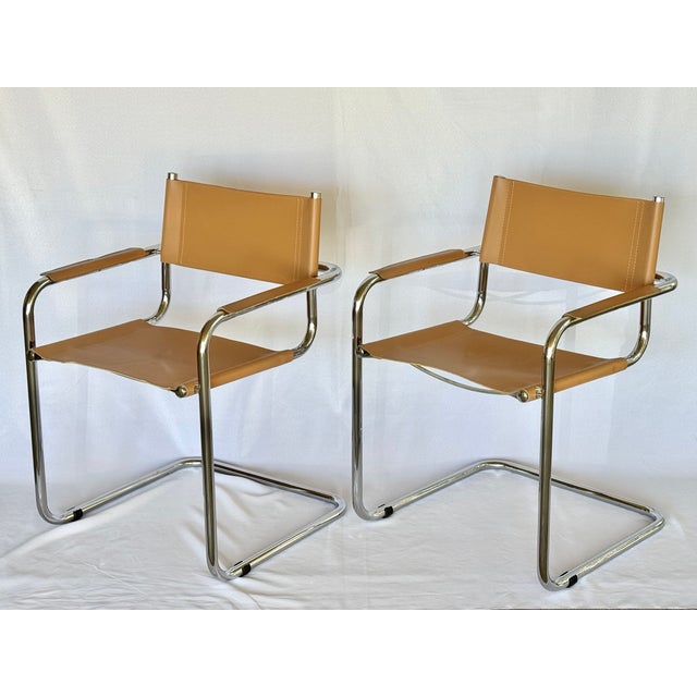 A pair of chrome chairs with leather seats and backs. The tubular cantilever design attributed to Mart Stam. Retains a...