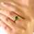 This elegant solitaire ring showcases a certified 1-carat square-cut natural emerald measuring 5 mm, set in luminous 14K...