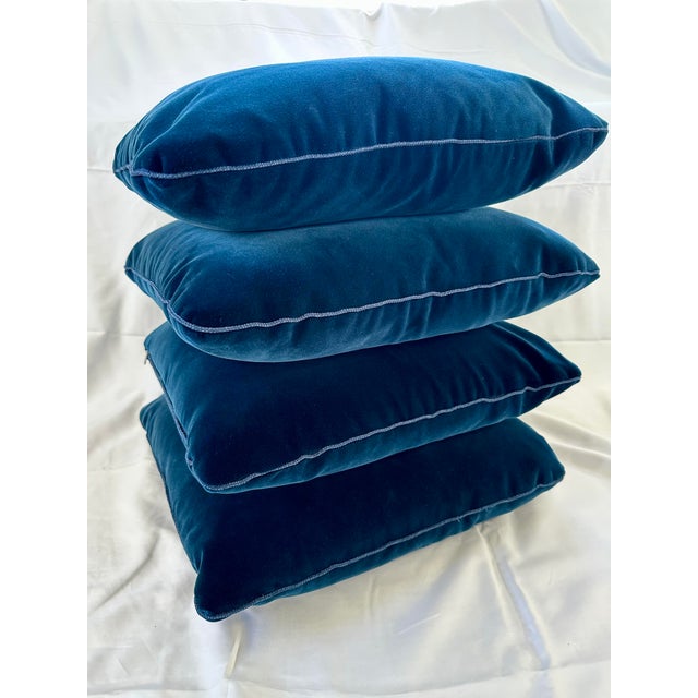 A set of four custom-made dark navy blue velvet pillows with contrasting cord trim. Each pillow measures 20” square and...