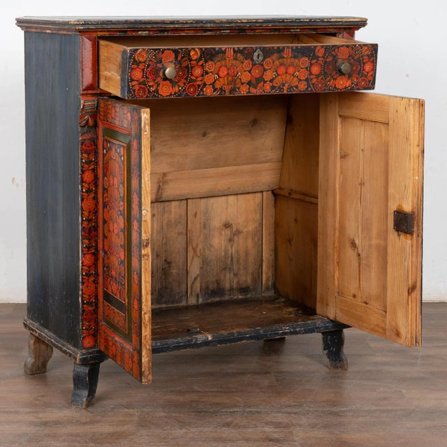 Bright colors abound in this original painted sideboard with traditional flowers in red and orange against a blue...