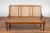 A rustic Javanese teak wood three-seat settee from the Turn of the Century with inset woven rattan seat and back. Infusing...