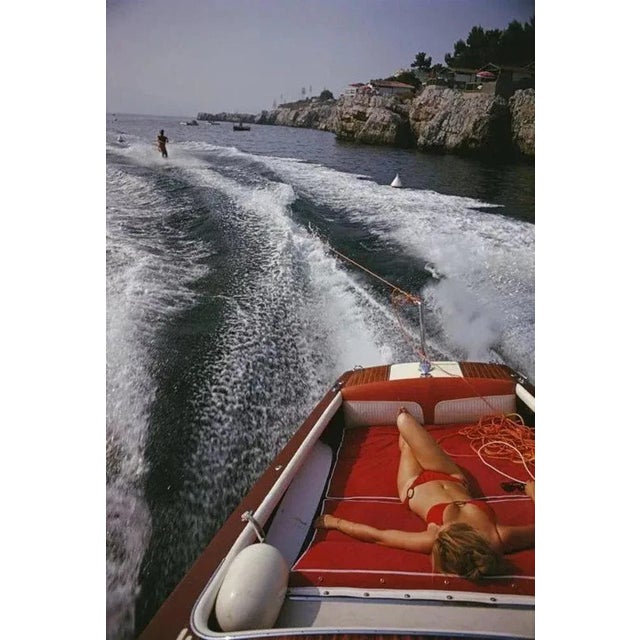 Leisure In Antibes 1969 by Slim Aarons Slim Aarons Limited Estate Edition A woman sunbathing in a motorboat as it tows a...