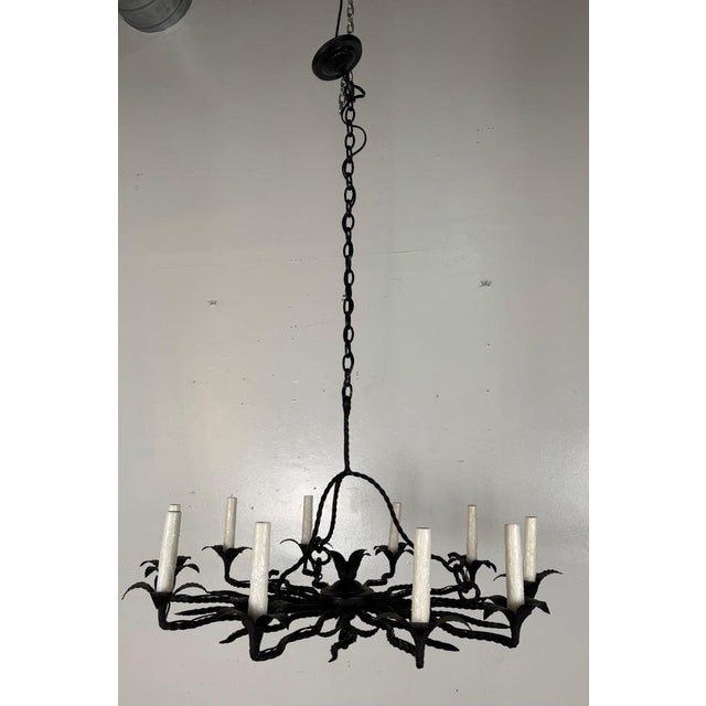 Spanish Revival Wrought Iron Twelve-Light Chandelier, circa 1930 A striking hand-forged wrought iron chandelier dating to...