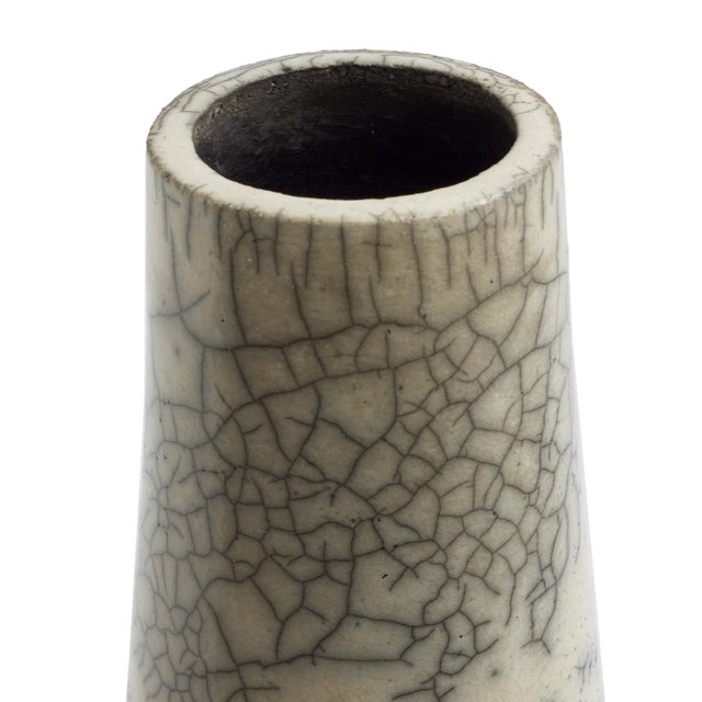 A Hana Vase, naturally colored, with a sleek surface that is elegantly graced with crackle' that emphasizes the harmonious...