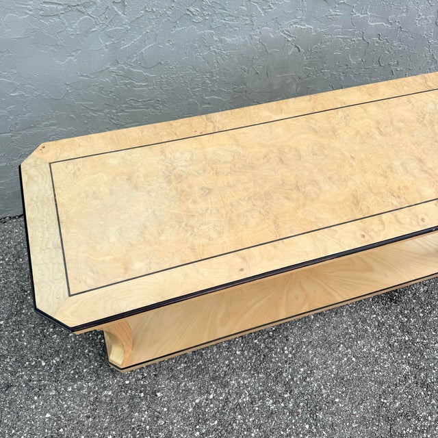 A refined vintage Art Deco console table, showcasing a beautifully figured burlwood top framed with a subtle contrasting...