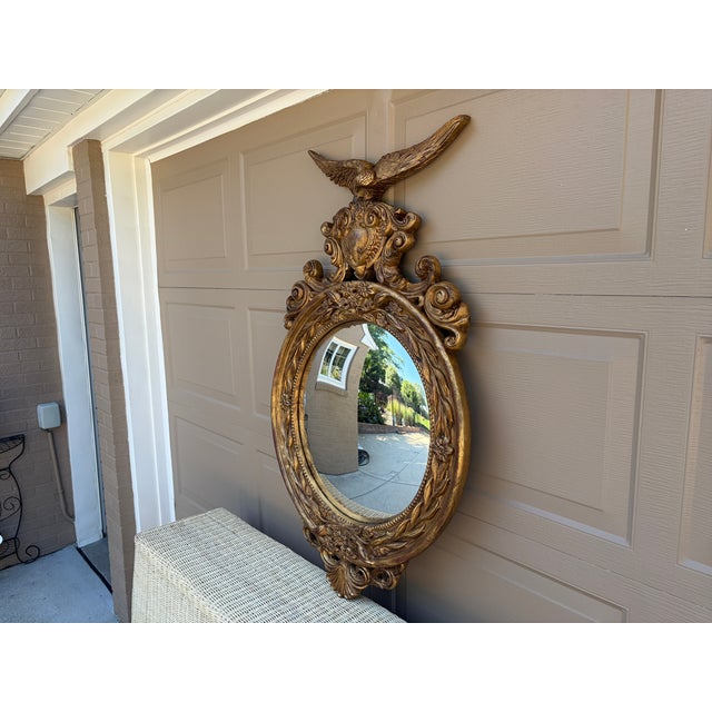 A beautiful large Federal-style convex mirror, crowned by a finely modeled spread-wing eagle above an elaborate...