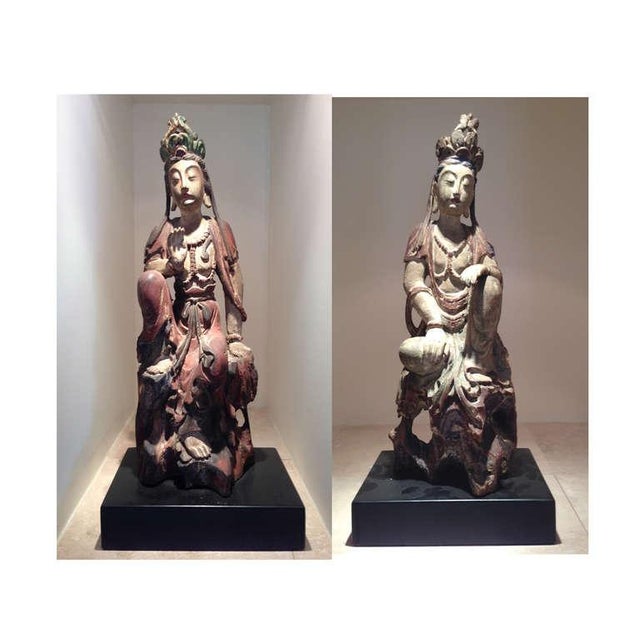 A pair of finely carved wood statues depicting near mirror images of two Bodhisattvas, likely dated to 19th century of...