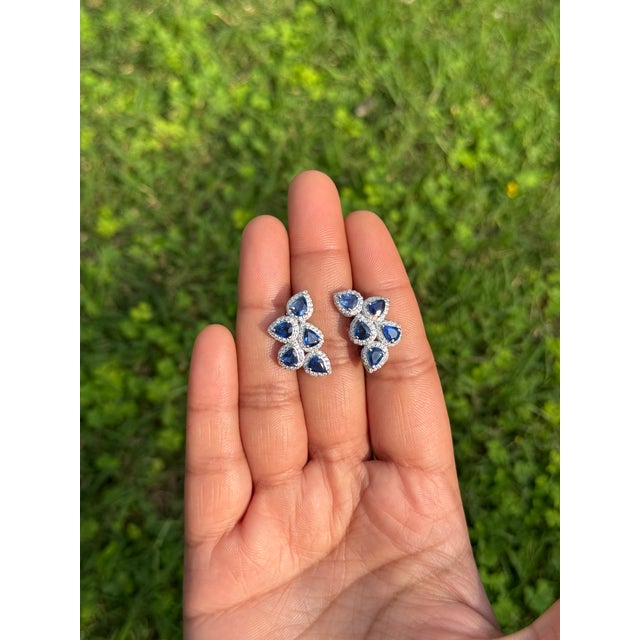 These elegant 4.02-carat pear-cut blue sapphire and diamond cluster stud earrings are crafted in 14K white gold. Each...