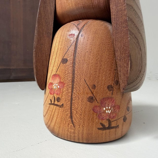Elegant vintage sōsaku kokeshi by Takeda Daisuke, with a soft natural wood tone and a calm, refined presence. The doll has...