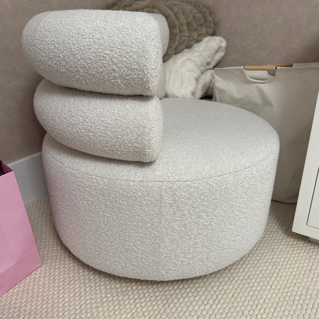 Elevate any room with this stylish and ultra-comfortable swivel accent chair. Upholstered in a soft, textured ivory bouclé...