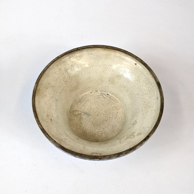 This porcelain bowl has a crackle glaze throughout. The blue peonies and pomegranates are hand painted around the bowl...