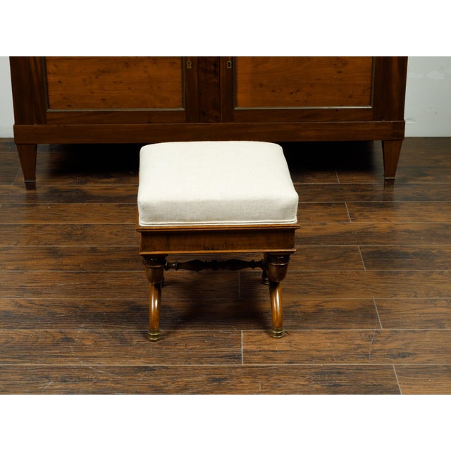 A French walnut X-form curule stool from the 19th century, with Corinthian capitals and new upholstery. Created in France...