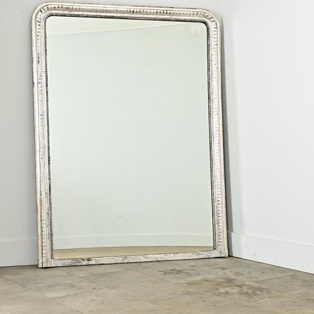 Orderly and architecturally inspired, the silver-gilt frame of this 19th century Louis Philippe mirror is meticulously...