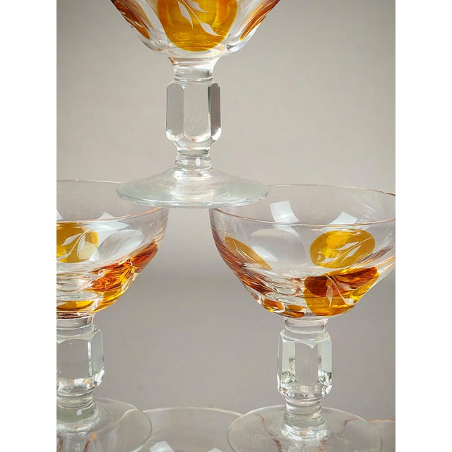 The glasses are clear, made of crystal glass. They feature gold leaf or petal patterns that adorn the bottom of each bowl....