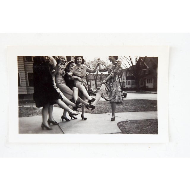 1940's snapshot photograph of young women kicking their legs and showing off. Unframed.