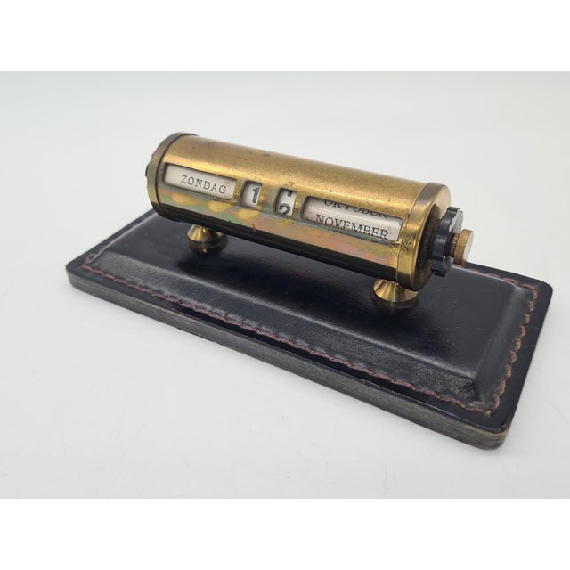 An elegant Dutch mechanical perpetual calendar designed for a desk or office. The calendar features a cylindrical brass...