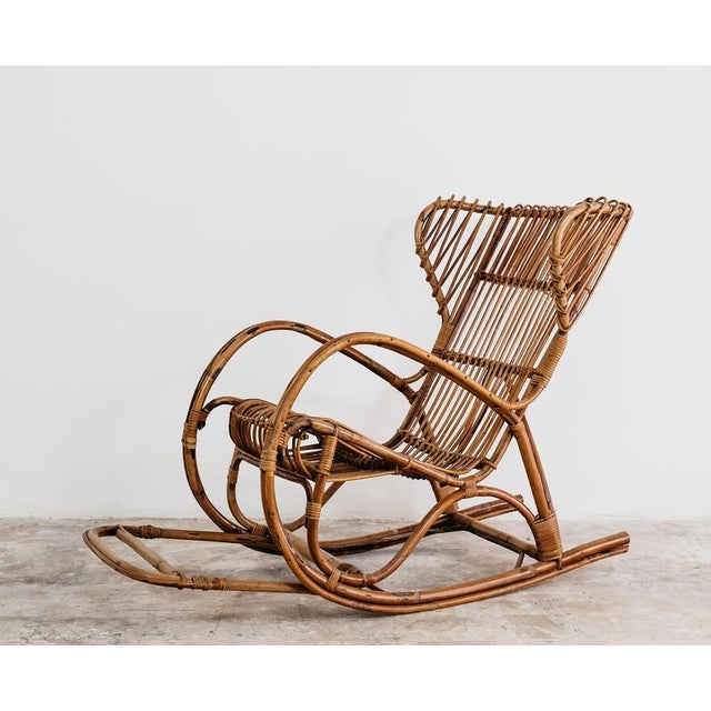 Elegant French rocking chair made in the 1960s of woven wicker and curved bamboo frame, an emblem of the natural, light...