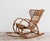 Elegant French rocking chair made in the 1960s of woven wicker and curved bamboo frame, an emblem of the natural, light...