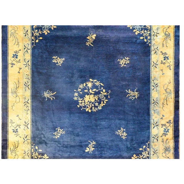 An amazing early 20th century Chinese Peking rug with a central floral medallion amidst a field of additional flowers on a...