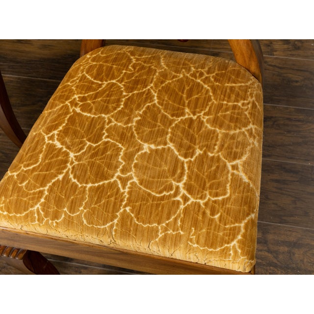A pair of Austrian Biedermeier period side chairs from the 19th century, with unusual carved open backs, curving legs,...